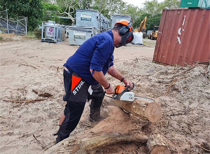 Man cutting a log wood with a chainsaw